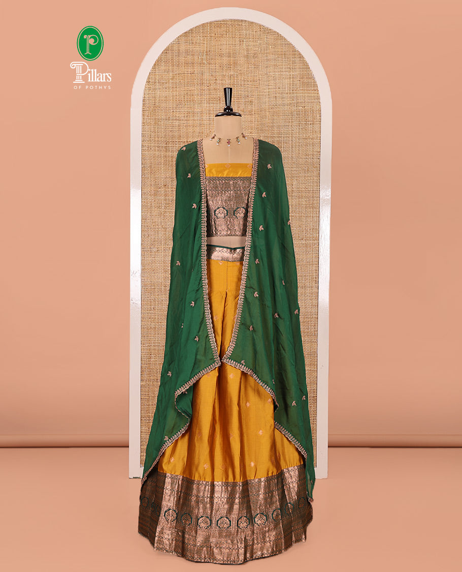 Yellow and Green Semi-Banarasi Half-Saree Prettified with Zari Buttas on Its Skirt, Complemented by a Contrast Traditional Zari Design Steeped Border, Paired with a Matching Blouse, and a Satin Georgette Embroidered Scallop Dhavani