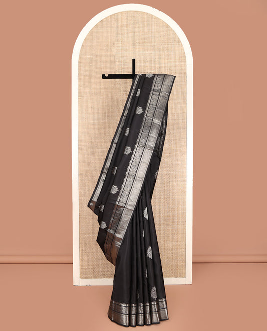 Black Kanchipuram Silk Saree, Dazzled with Zari Buttas All Over Its Body, Highlighted by Zari Border of Rekku, Kathir, Vanki, and Mayil Designs, Pallu of Jaal Design, and Paired with a Matching Blouse