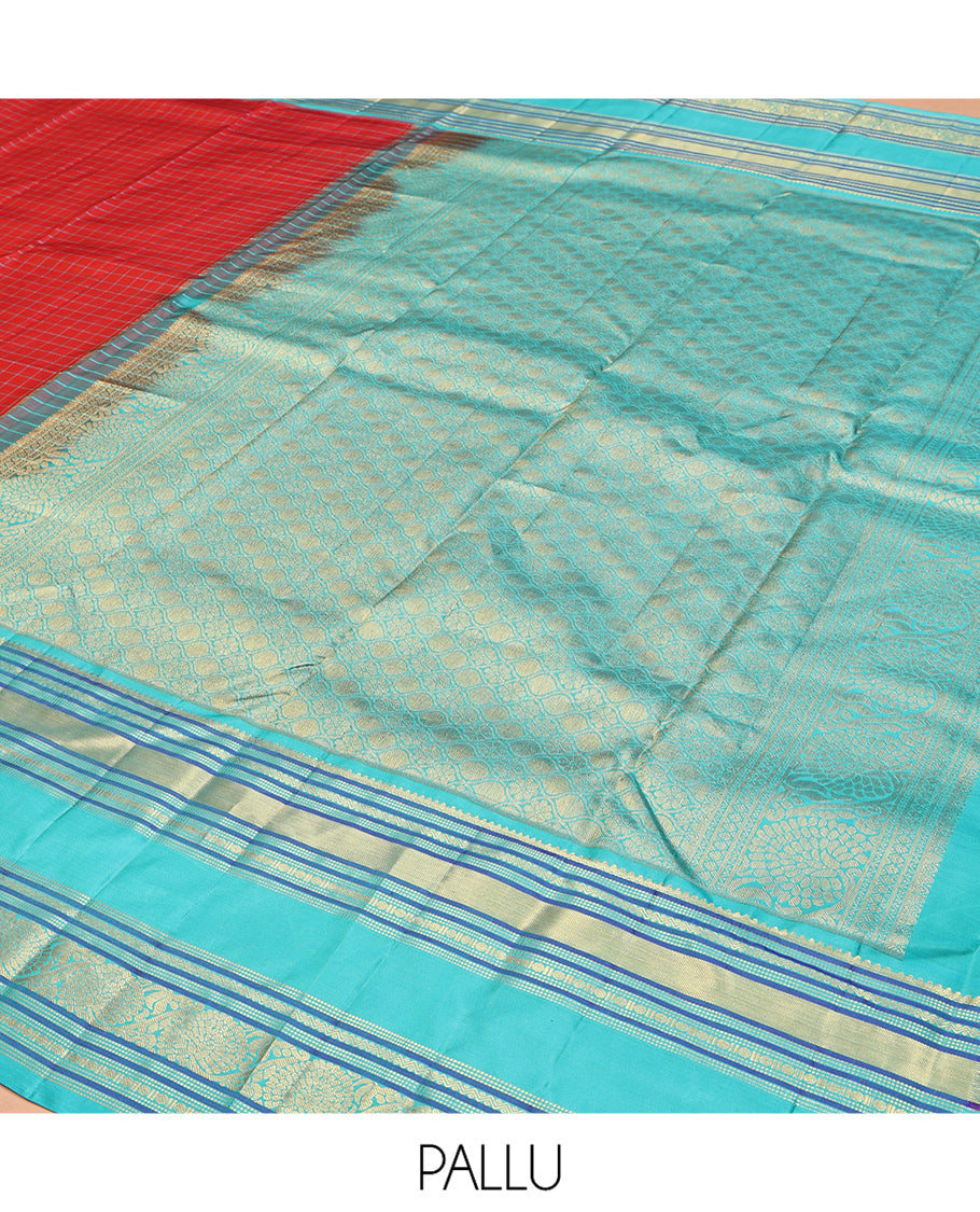 Tomato Red and Blue Vasundhara Silk Saree, Subtly Sparkled With Pattu Nool Kattam On Its Body, Complemented by Contrast Rettai Pettu Border of Salngai, Muthu, Neli, Rudraksham, and Dhavana Kodi Designs, Grand Pallu and Paired with a Contrast Blouse