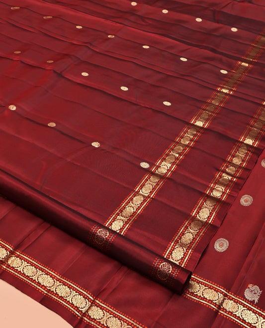 Maroon Kanchipuram Silk Saree, Adorned with Chakram Buttas, Highlighted by a Rettai Pettu Zari Border of Muthu, Banaras, and Cross Kamalam Designs, Mayil-Chakram Pallu and a Matching Blouse
