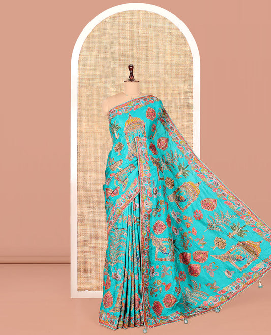Blue Dola Silk Saree, Featuring Colorful Flora, Fauna, and Mughal-Style Print on Its Body, Highlighted by Kaleidoscopic-Colored Floral-Bird Embroidered Border, Pallu Mirroring the Same Design, and Paired with a Contrast Blouse