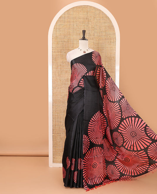 Black-base plain body khadi cotton saree with batik-style peach-color radiant sunburst design on its border & pallu, plain black blouse