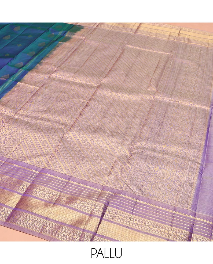 Blue Vasundhara Silk Saree, Adorned with Thilakam and Floral Buttas on Its Body, Complemented by a Contrast Border of Rekku, Muthu, Kathir, Kamalam, Diamond, and Mayil Kann Designs, Pallu Steeped with Intricate Designs, and Paired with a Contrast Blouse