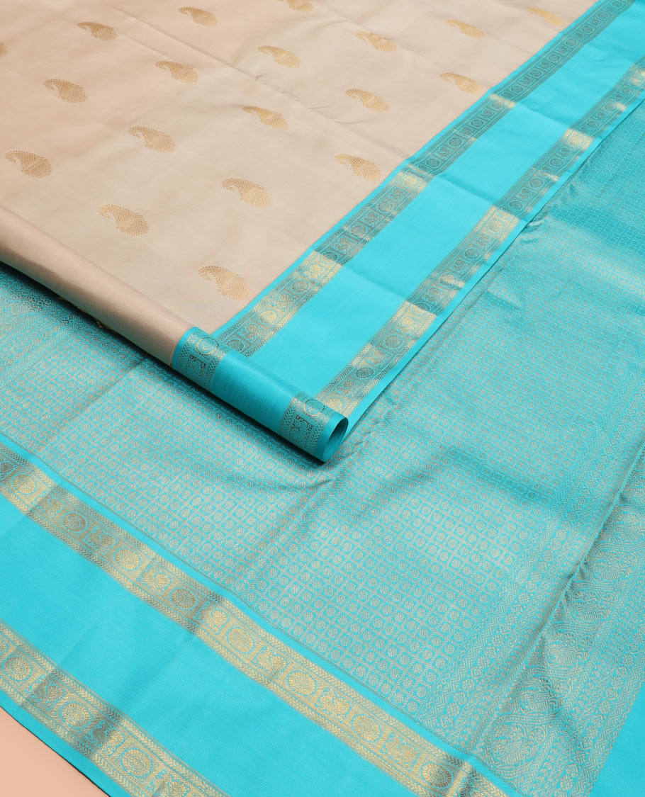 Cream manga buttas Kanchipuram silk saree, contrast rettai pettu border of kathir and annam chakram motifs, and butta enclosed checked pallu