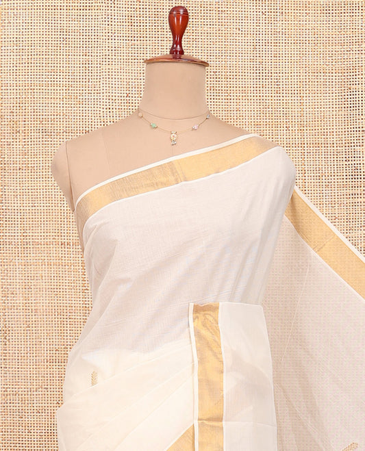 Cream Kerala Cotton Saree, Decorated with Thread and Zari Buttas All Over Its Body, a Zari Bavanji Border, Pallu of Intricate Designs, and Paired with a Matching Blouse