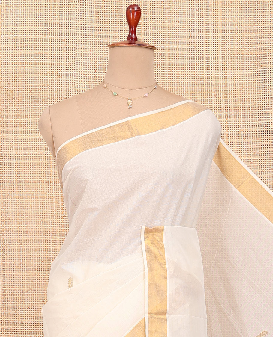 Cream Kerala Cotton Saree, Decorated with Thread and Zari Buttas All Over Its Body, a Zari Bavanji Border, Pallu of Intricate Designs, and Paired with a Matching Blouse
