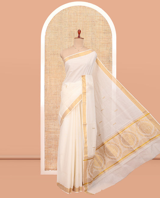 Cream Kerala Cotton Saree, Decorated with Thread and Zari Buttas All Over Its Body, a Zari Bavanji Border, Pallu of Intricate Designs, and Paired with a Matching Blouse
