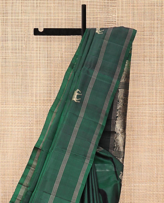Green Mayuri Soft Silk Saree, Elevated with Horse Buttas All Over Its Body, Subtly Woven Striped Border, Contrast Pallu Depicting Floral and Elephant Designs, and Paired with a Contrast Blouse