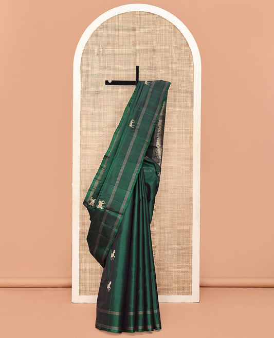 Green Mayuri Soft Silk Saree, Elevated with Horse Buttas All Over Its Body, Subtly Woven Striped Border, Contrast Pallu Depicting Floral and Elephant Designs, and Paired with a Contrast Blouse