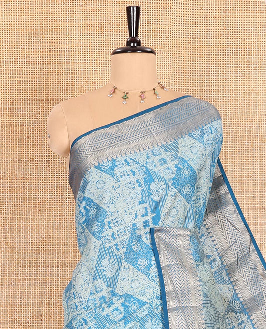Blue Semi-Tussar Saree Meticulously Crafted with Floral-Enclosed Diamond Patterns Printed Across the Body, Featuring a Subtly Woven Border with Traditional Zari Designs, and a Pallu Elevated with Zari Stripes, Paired with a Matching Blouse