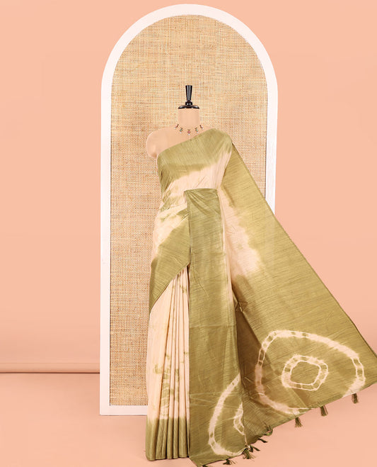 Cream and Green Jute Tussar Saree Subtly Accentuated with Shibori Print, Captivating Contrast Border of Shibori Print, Pallu of the Same Shibori Print, and Comes with a Contrast Blouse