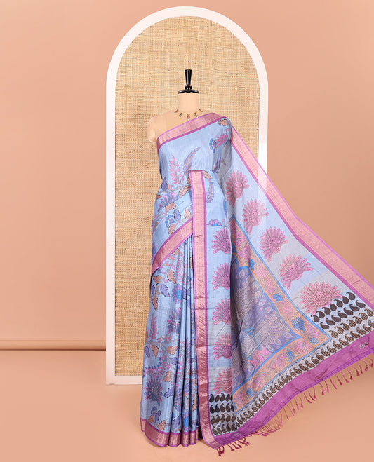 Blue Manipuri Silk Saree Embellished with Kalamkari Floral and Peacock Prints All Over Its Body, Complemented by a Contrast Zari Border, Pallu Depicts a Big Peacock and Paisleys, and Paired with a Contrast Printed Blouse