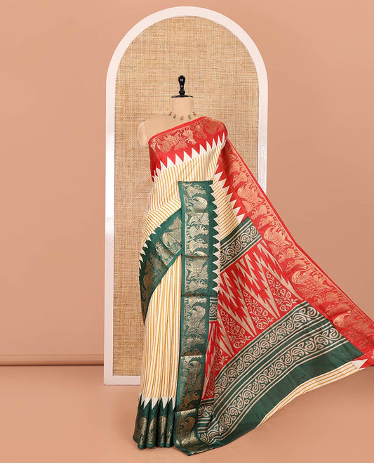 Chikku Base Dola Silk Saree Subtly Sparkled with Yellow Stripes All Over Its Body, Complemented by a Contrast Ganga-Jamuna Border of Human Figurines and Elephant Motifs, Pallu of Floral-Paisley Print, and Paired with a Contrast Blouse