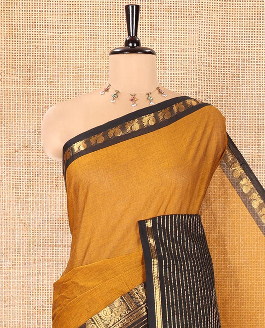 Mustard Plain Chettinad Cotton Saree, Complemented by a Contrast Zari Traditional Border Steeped with  Peacock Designs, Subtly Striped Pallu, and Paired with a Matching Blouse