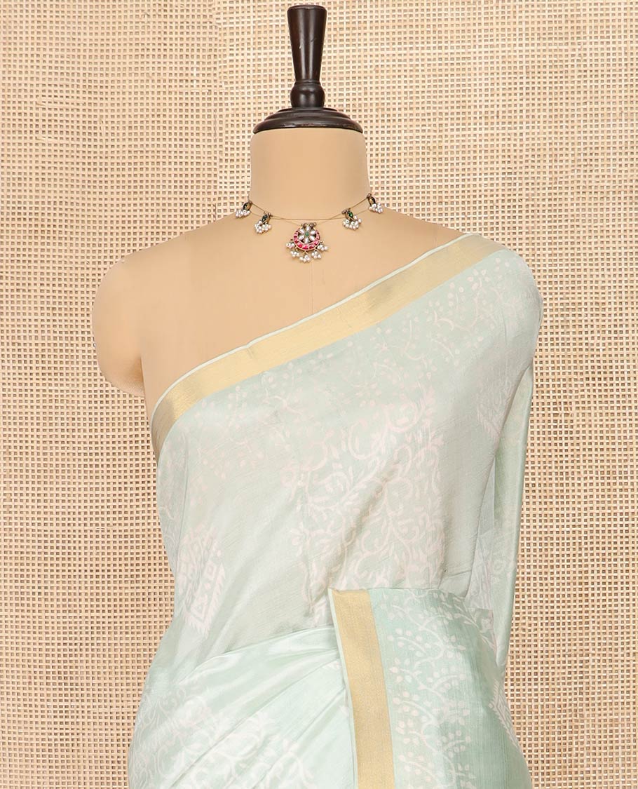 Pastel Green Banana Pith Saree Sparsely Sparkled with Intricate Motifs Printed All Over Its Body, Zari Bavanji Border, Pallu of Print and Zari Work, and Paired with a Matching Blouse
