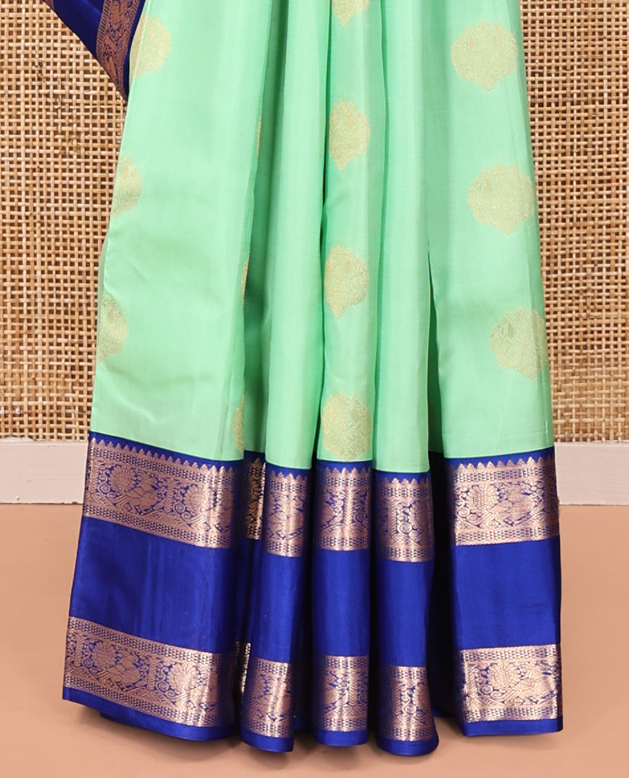 Pastel Sea Green Vasundhara Silk Saree, Ornamented with Zari Buttas All Over Its Body, Complemented by a Contrast Rettai Pettu Border of Rekku, Ara Maadam, and Mayil Designs, Grand Pallu, and Paired with a Contrast Blouse
