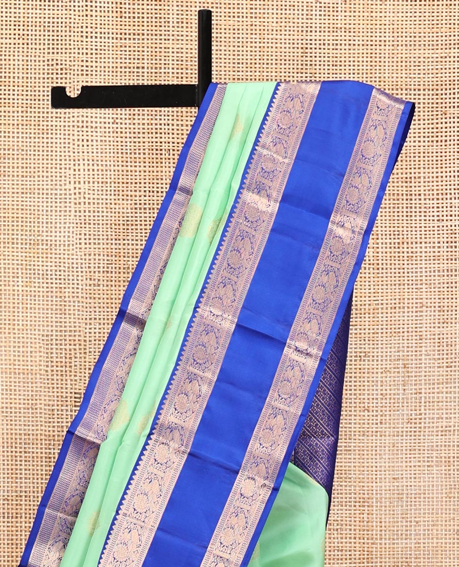 Pastel Sea Green Vasundhara Silk Saree, Ornamented with Zari Buttas All Over Its Body, Complemented by a Contrast Rettai Pettu Border of Rekku, Ara Maadam, and Mayil Designs, Grand Pallu, and Paired with a Contrast Blouse