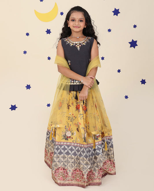 Yellow cholly set features a floral printed skirt, contrast embroidered puff-sleeve blouse & net dupatta