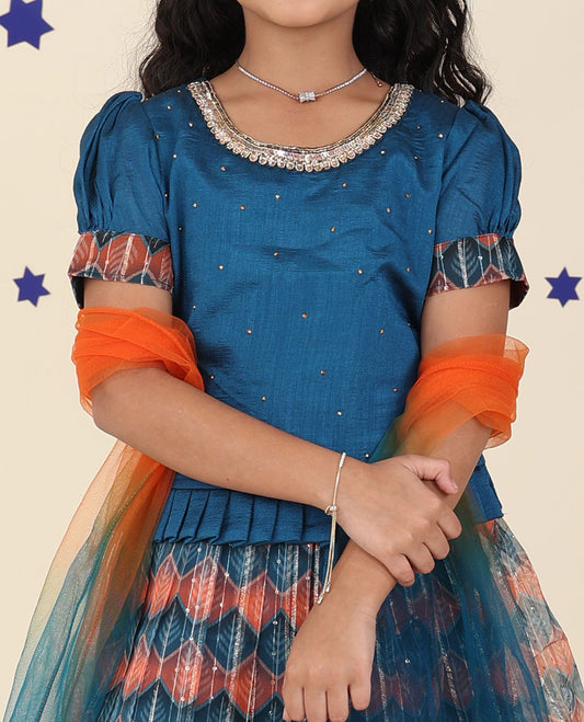 Blue cholly set features intricately printed skirt, embroidered puff-sleeve blouse & net dupatta