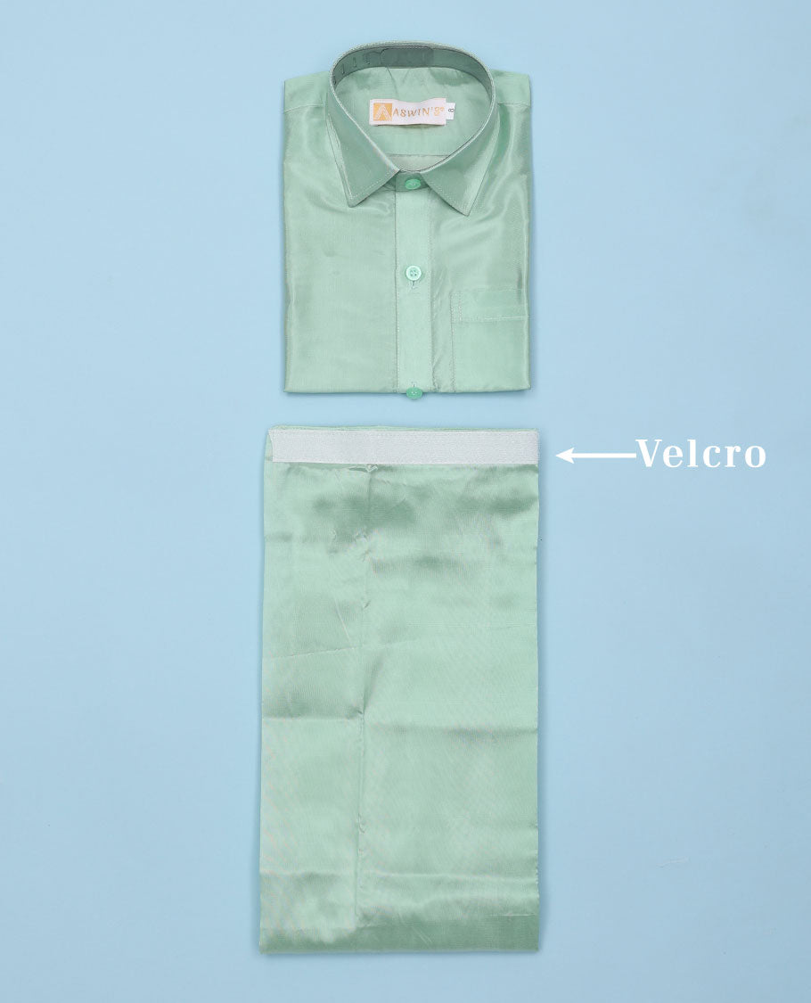 Pista green art-silk boys dhoti set features a solid half-sleeve shirt & zari border velcro dhoti 