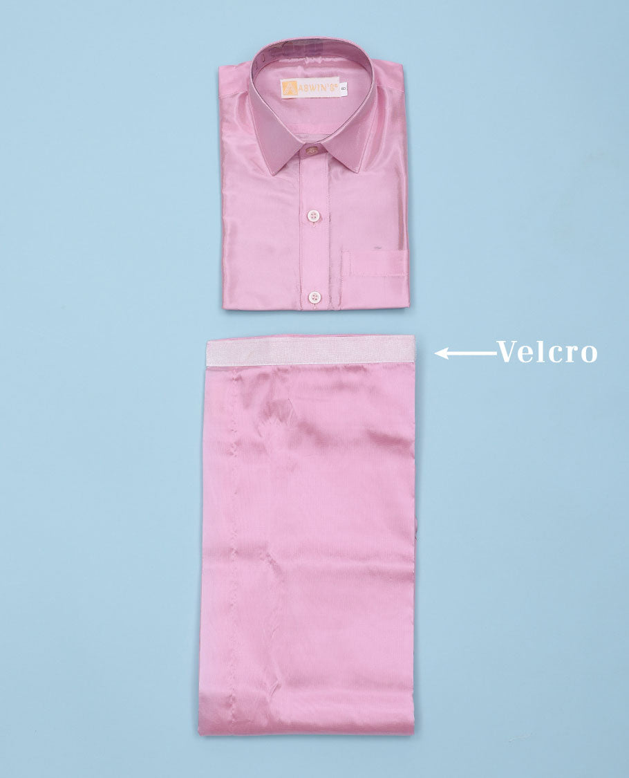 Pink art-silk boys dhoti set features a solid half-sleeve shirt & zari border velcro dhoti 