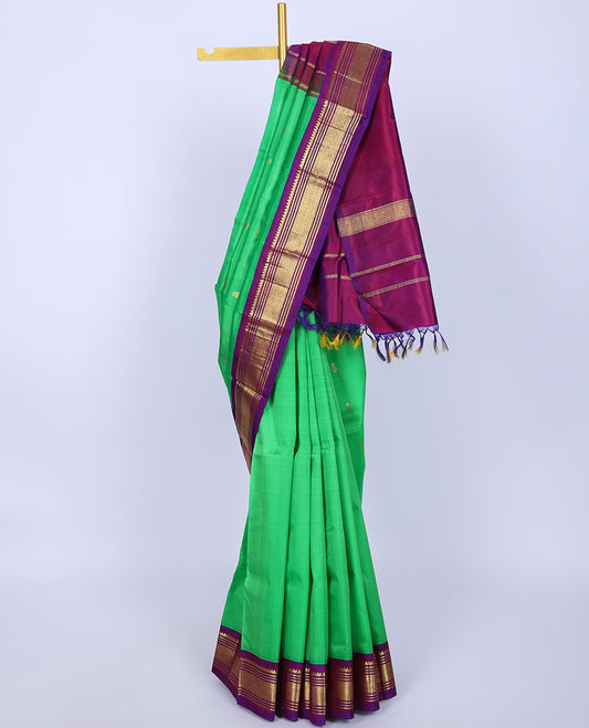 Green kancheepuram silksaree with buttas,contrast zari design pallu & korvai border of thilakam mokku,muthu,banaras,jaal