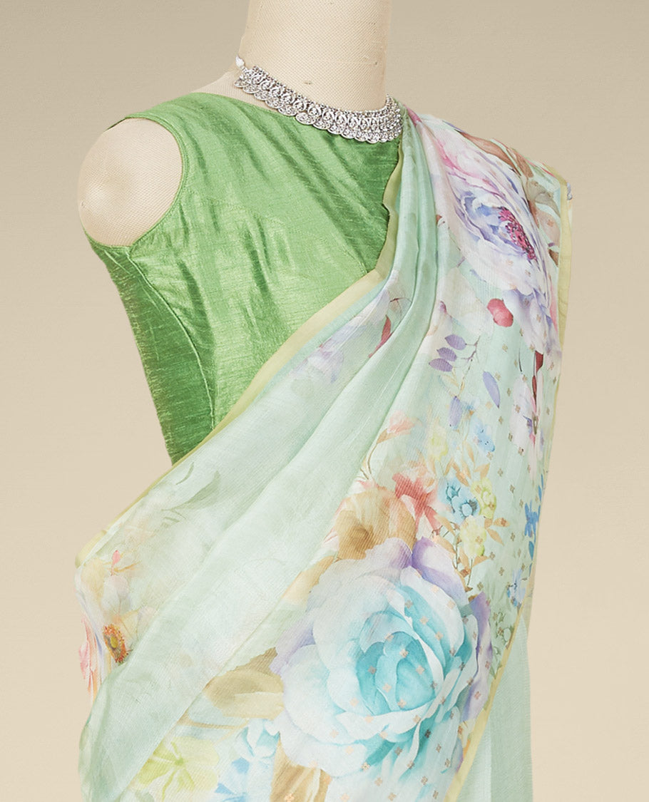 Borderless pastel green organza saree features kaleidoscopic-colored floral motifs print