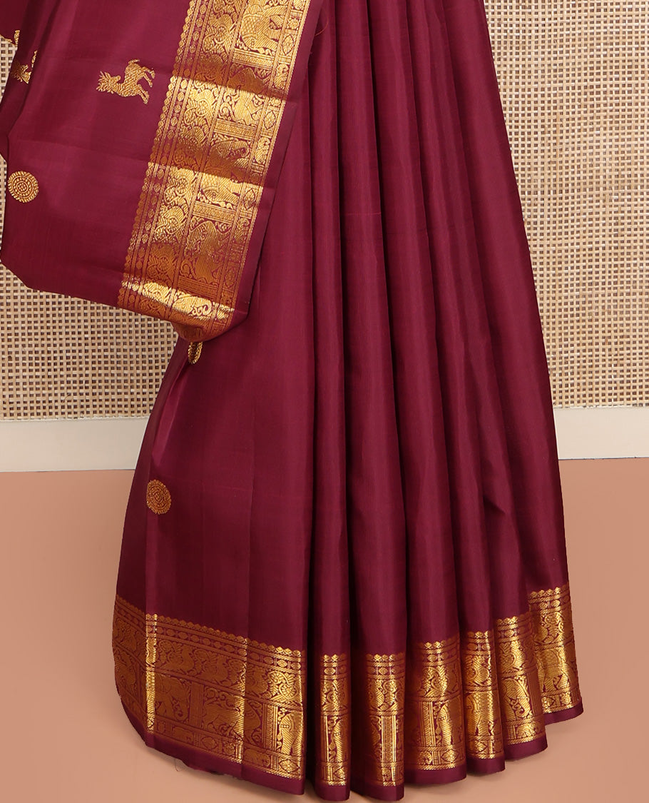 Red Kanchipuram Silk Saree, Lightly Embellished with Kuthirai and Chakram Buttas All Over Its Body, Highlighted by Zari Border of Salngai, Poun, Mayil, Yaali, and Yaanai Designs, Pallu of Ara Maadam Design, and Paired with a Matching Blouse
