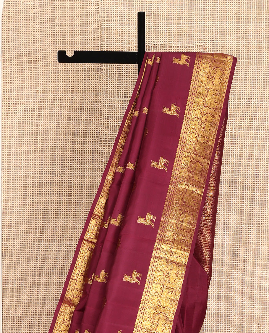 Red Kanchipuram Silk Saree, Lightly Embellished with Kuthirai and Chakram Buttas All Over Its Body, Highlighted by Zari Border of Salngai, Poun, Mayil, Yaali, and Yaanai Designs, Pallu of Ara Maadam Design, and Paired with a Matching Blouse
