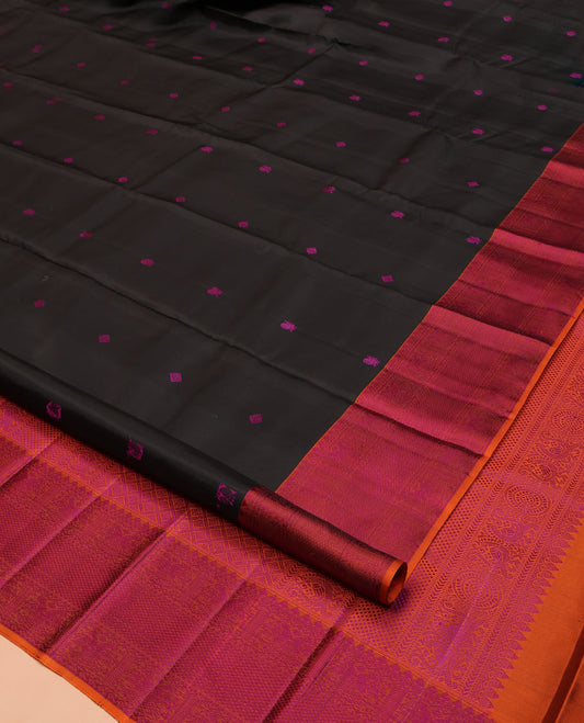 Black Kanchipuram Silk Saree, Masterfully Woven with Mayil-Chakram Buttas All Over Its Body, Complemented by a Contrast Border of Thilakam Mokku, Iruthalai Pakshi, and Kuyil Kann Designs, and Pallu of Jaal Designs, and Paired with a Contrast Blouse