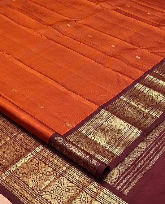 Orange Kanchipuram Silk Saree, Showcasing Zari Buttas All Over Its Body, Complemented by a Contrast Border of Muthu, Kathir, Kamalam, and Chakram Designs, Grand Jaal Pallu, and Paired with a Contrast Blouse