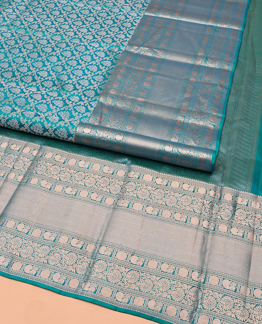 Rama Blue Kanchipuram Wedding Silk Saree, Mesmerized with Jaal Jacquard on Its Body, Highlighted by a Zari Border of Thilakam Mokku, Poun, Mayil, and Kodi Visiry Designs, Grand Pallu Steeped with Chakram Designs, and Paired with a Matching Blouse
