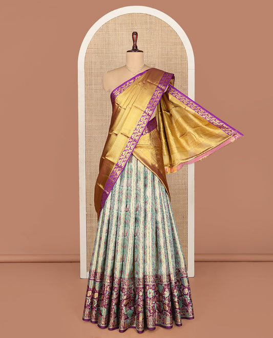 Green Pure Silk Half-Saree, Artfully Detailed with Floral Jacquard All Over Its Skirt, Complemented by a Contrast Border of Yaanai, Mayil, and Kodi Visiry Designs, Paired with a Contrast Blouse, and Comes with an Intricately Designed Dhavani