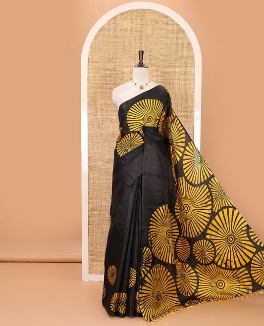 Black-base plain body khadi cotton saree with batik-style yellow-color radiant sunburst design on its border & pallu, plain black blouse