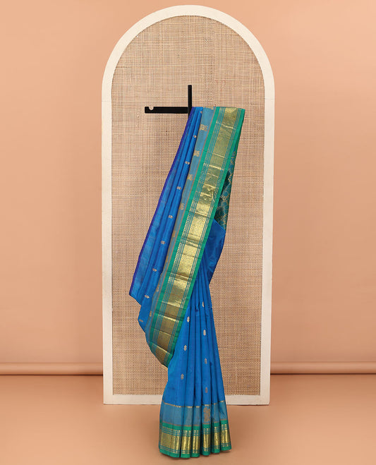 Blue Kanchipuram Silk Saree, Bedecked with Zari Buttas All Over Its Body, Complemented by Contrast One-Sided Border of Panner Sombu, Banaras, Muthu and Jaal Designs, Pallu Features Floral-Diamond Designs, and Comes Without a Blouse