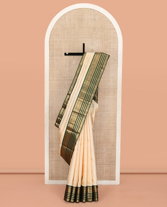 Cream Vasundhara Silk Saree, Enthralled with Zari Buttas All Over Its Body, Complemented by a Contrast Border of Muthu, Diamond, Kuthirai, Chakram, and Diamond Designs, Grand Pallu, and Paired with a Contrast Blouse