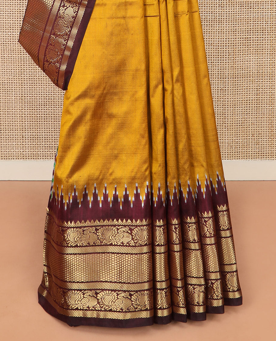 Mustard Plain Ikkat Silk Saree, Complemented by a Contrast Temple Traditional Zari Motif Woven Border, Pallu Adorned with Vibrant Jaal Design, and Paired with a Multi-Coloured Blouse