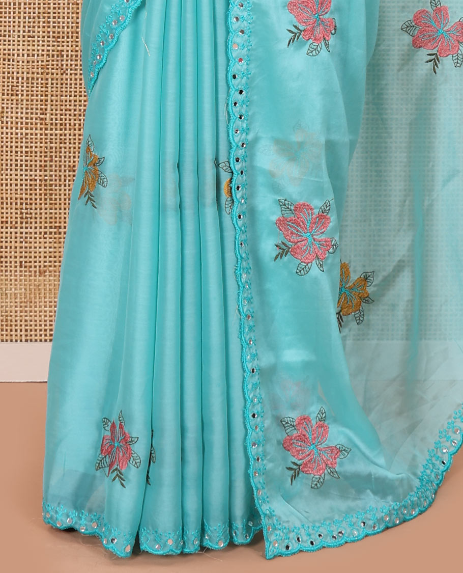 Blue floral motifs embroidered rangoli chiffon saree with mirror work border, embroidered pallu, and a contrast intricate scallop design embroidered blouse