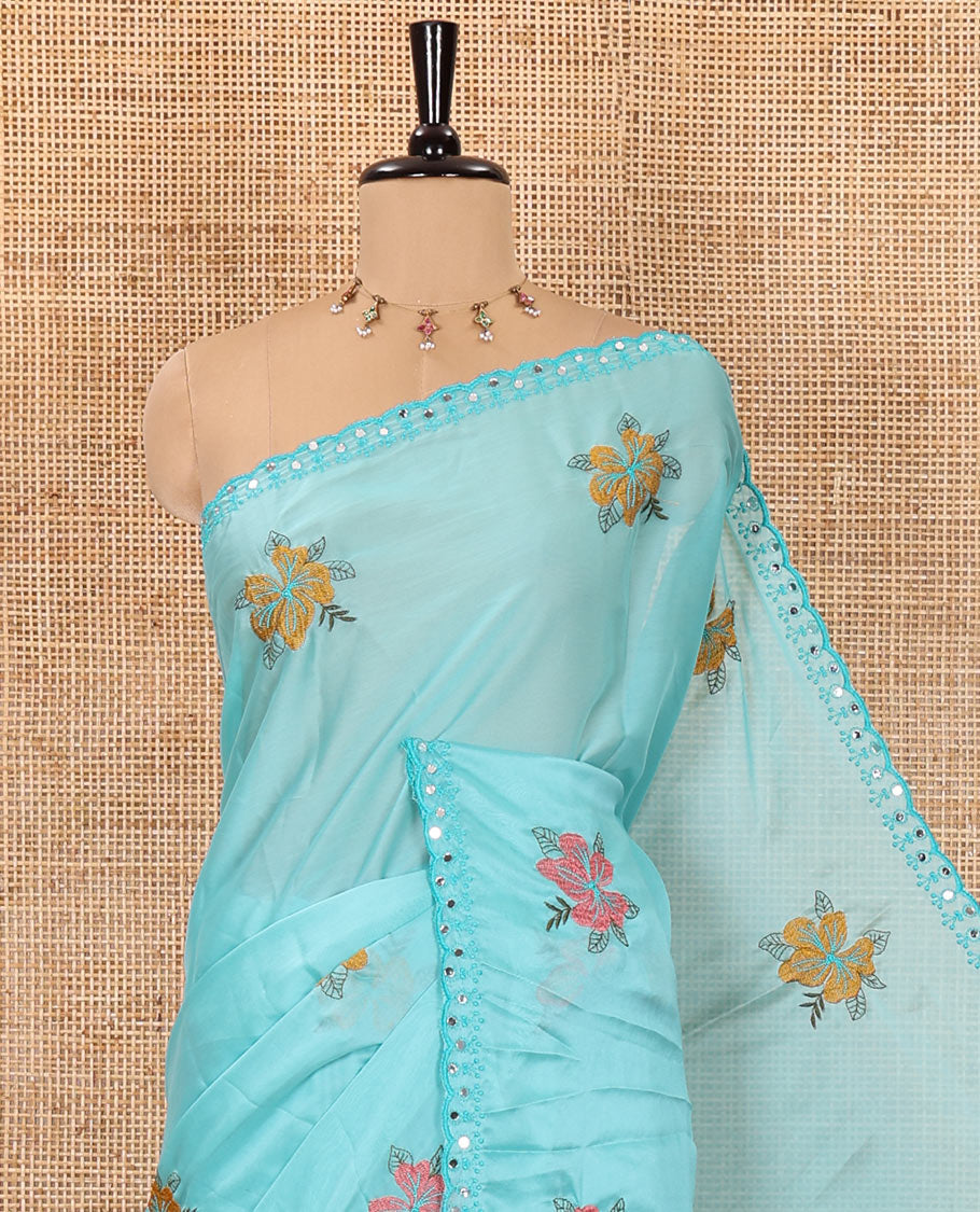 Blue floral motifs embroidered rangoli chiffon saree with mirror work border, embroidered pallu, and a contrast intricate scallop design embroidered blouse