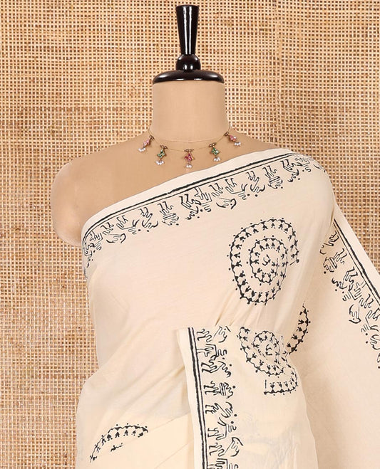 Cream South Cotton Saree Featuring Warli-Village Theme Printed All Over Its Body, Subtly Sparked with Warli Printed Border, and Paired with a Contrast Patola-Style Printed Blouse