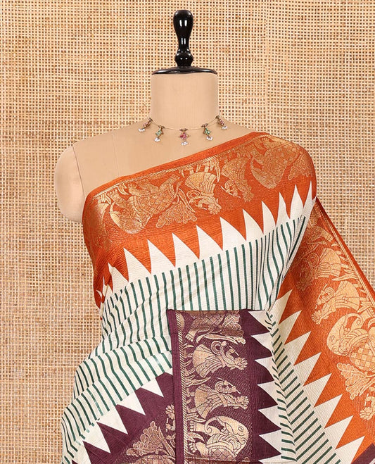 Chikku Base Dola Silk Saree Subtly Sparkled with Green Stripes All Over Its Body, Complemented by a Contrast Ganga-Jamuna Border of Human Figurines and Elephant Motifs, Pallu of Floral-Paisley Print, and Paired with a Contrast Blouse