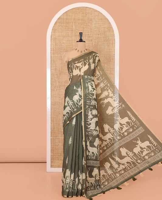 Green Christmas-Themed Linen Cotton Saree, Decorated with Christmas Tree Motifs Printed on Its Body, a Subtle Piping Border, Pallu of Christmas-Themed Print, and Paired with a Contrast Floral Printed Blouse