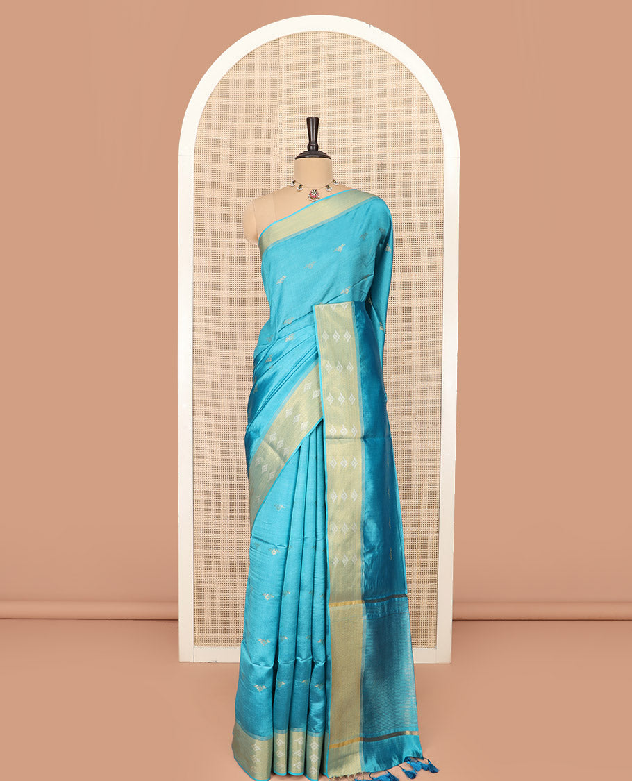 Blue Banana Pith Saree Elegantly Framed with Zari Buttas, Artfully Detailed Border with Zari Designs, Gleaming Zari Stripes Woven Pallu, and Paired with a Matching Plain Blouse