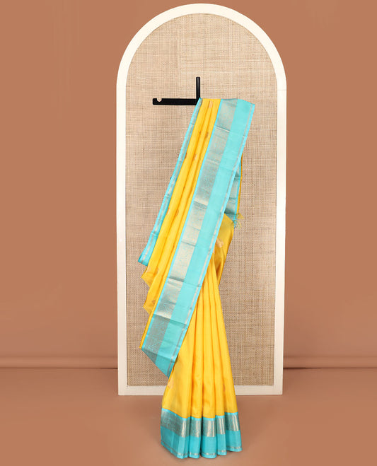 Yellow Vasundhara Silk Saree Embellished with Zari Buttas, Complemented by a Contrast Rettai Pettu Border of Salngai, Neli, Kathir, Mayil, and Kathir Designs, Featuring a Pallu of Jaal Designs, and a Contrast Blouse