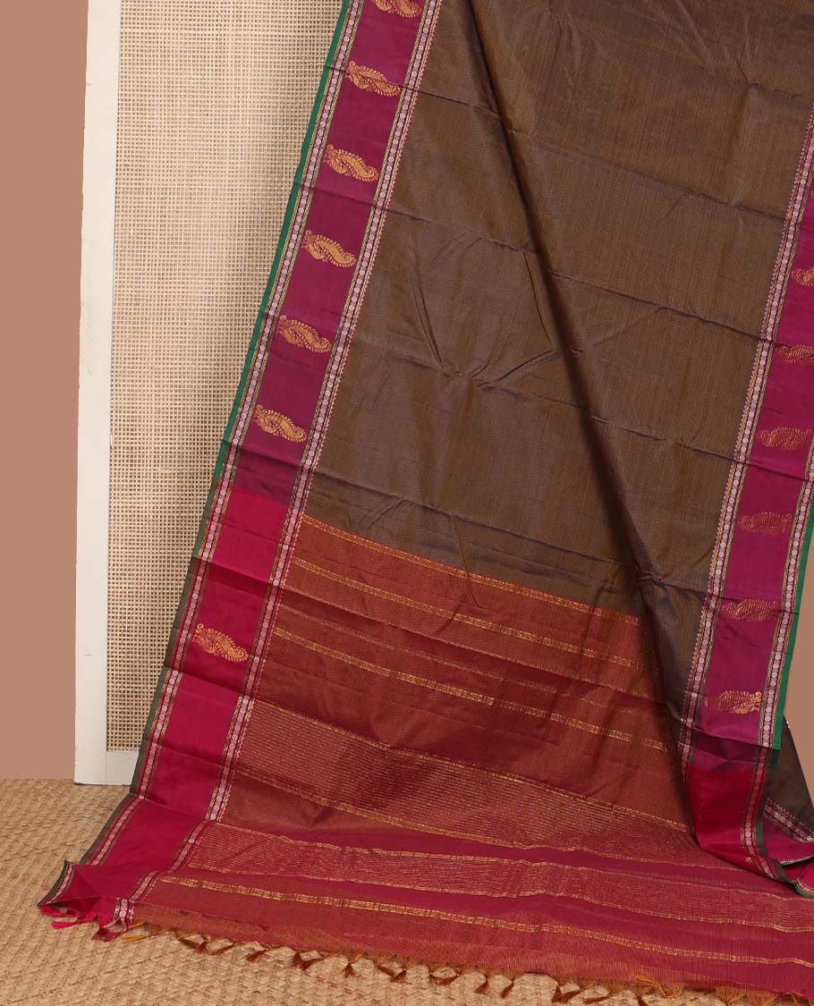 Brown plain Kanchipuram silk saree, contrast border of rekku, muthu, rudraksham, and mayil designs, and zari striped pallu