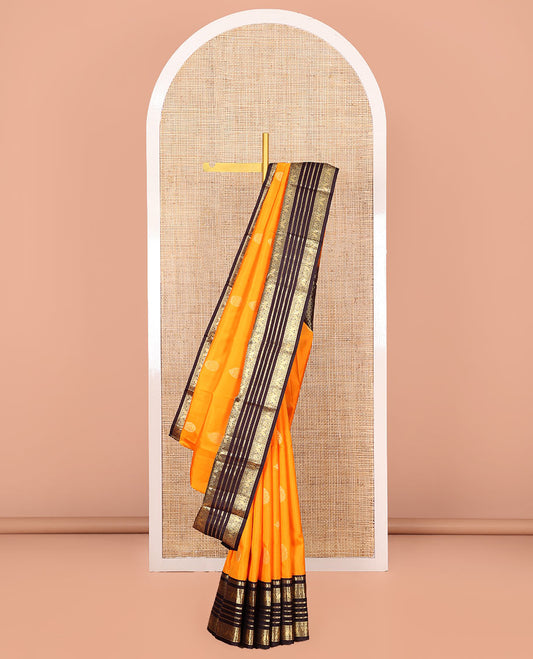 Yellow Vasundhara Silk Saree Subtly Sparkled with Zari Buttas  All Over Its Body, Complemented by a Contrast Border of Thilakam, Neli, Manga, Mayil, and Mayil Kann Designs, Finely Zari Detailed Pallu, and Paired with a Contrast Blouse