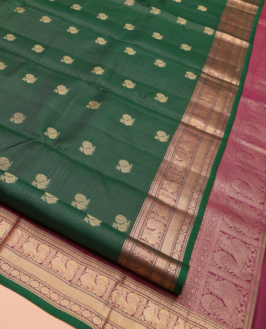 Green Kanchipuram Silk Saree, Beautified with Mayil Buttas and Zari Stripes on Its Body, Complemented by Contrast Border of Muthu, Diamond, Mayil, and Laddu Kamalam Designs, Diagonally Striped Pallu, and Paired with a Contrast Blouse