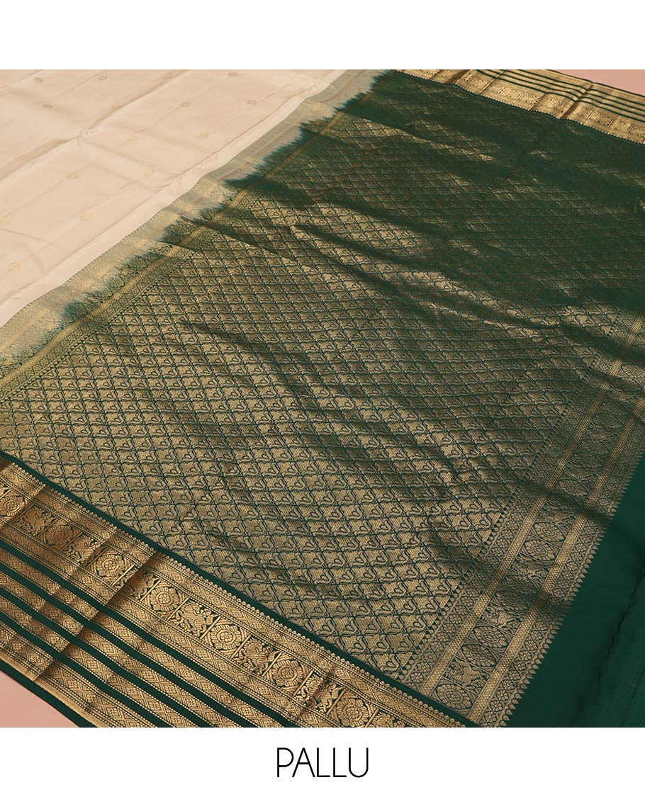 Cream Vasundhara Silk Saree, Enthralled with Zari Buttas All Over Its Body, Complemented by a Contrast Border of Muthu, Diamond, Kuthirai, Chakram, and Diamond Designs, Grand Pallu, and Paired with a Contrast Blouse
