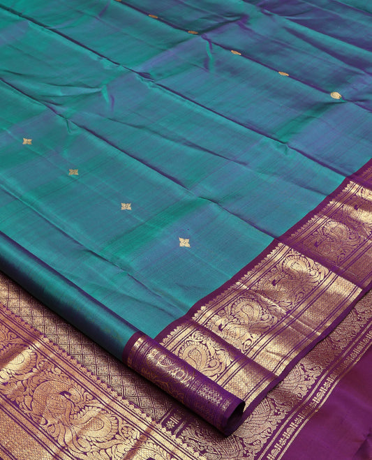 Blue Kanchipuram Silk Saree, Features Zari Buttas All Over Its Body, Complemented by a Contrast Border of Mayil Kann, Mayil, and Jaal Designs, Grand Jaal Pallu, and Paired with a Contrast Blouse
