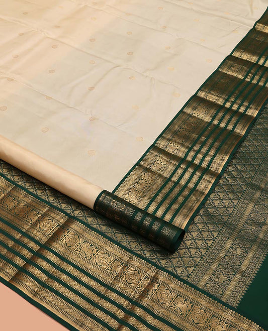 Cream Vasundhara Silk Saree, Enthralled with Zari Buttas All Over Its Body, Complemented by a Contrast Border of Muthu, Diamond, Kuthirai, Chakram, and Diamond Designs, Grand Pallu, and Paired with a Contrast Blouse
